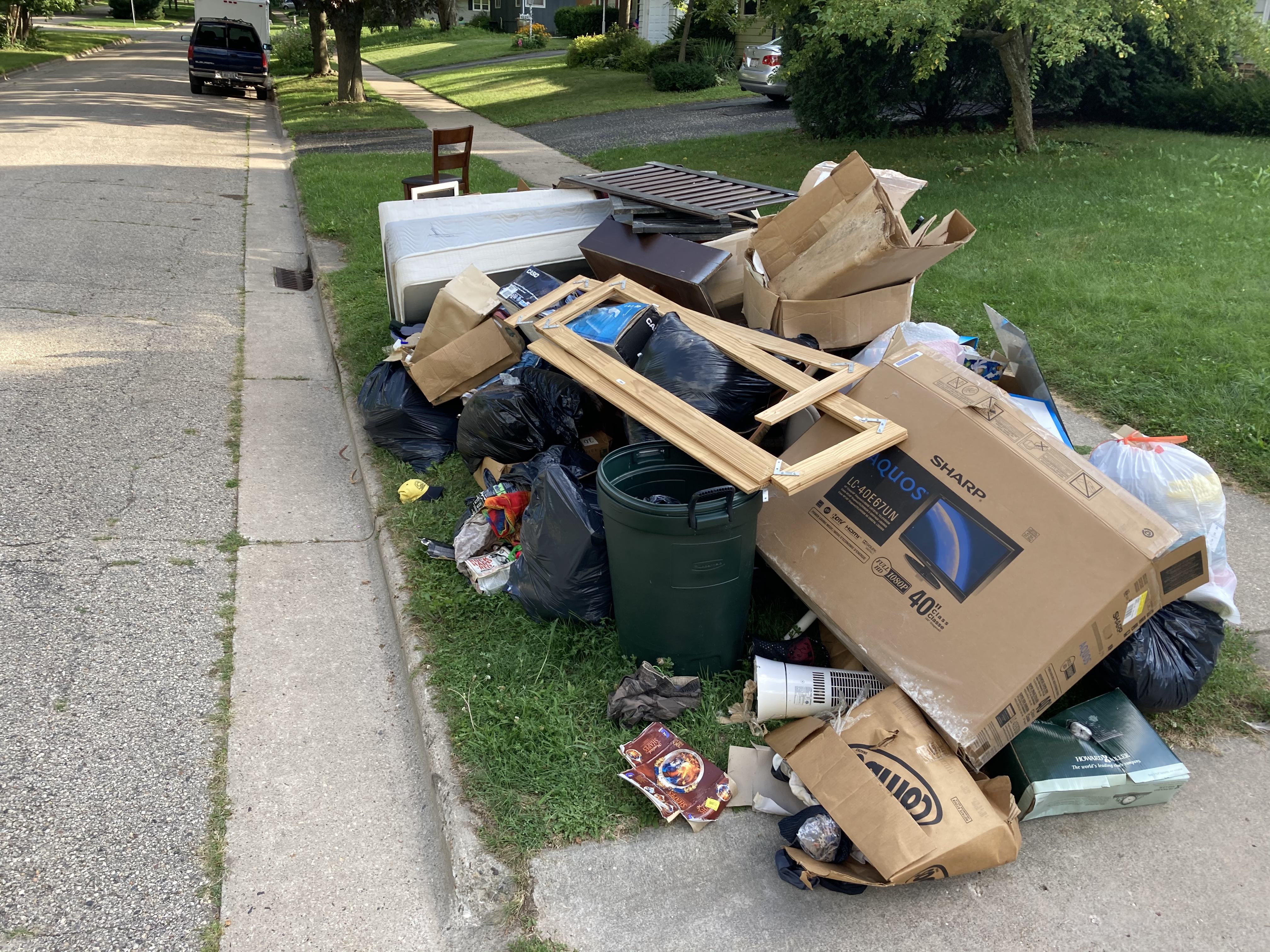 Large pile of garbage on curb.